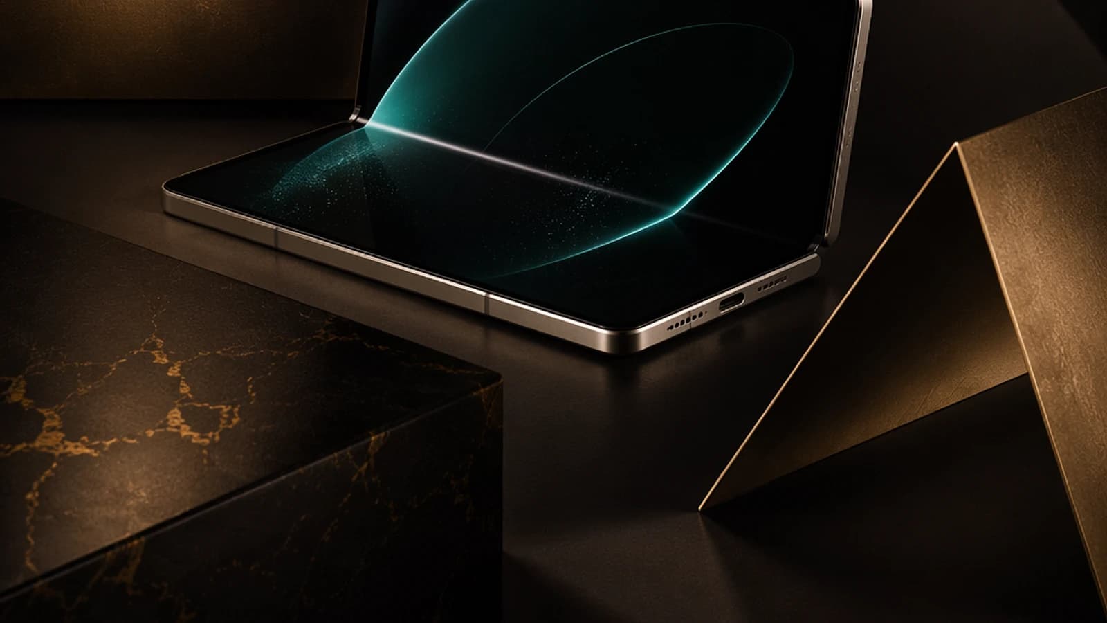 Ordinateur portable ouvert sur une surface sombre avec des éléments géométriques dorés.